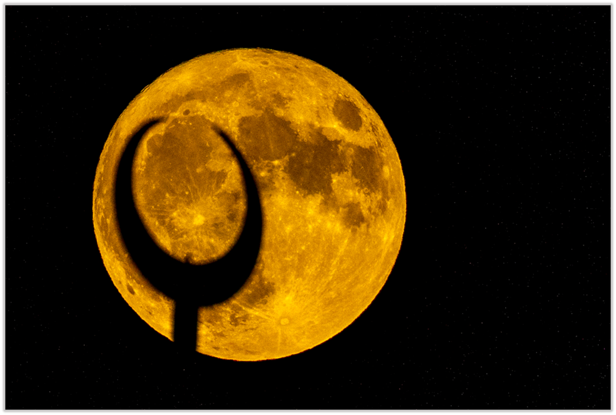 A yellow moon with a crescent moon shadow

Description automatically generated